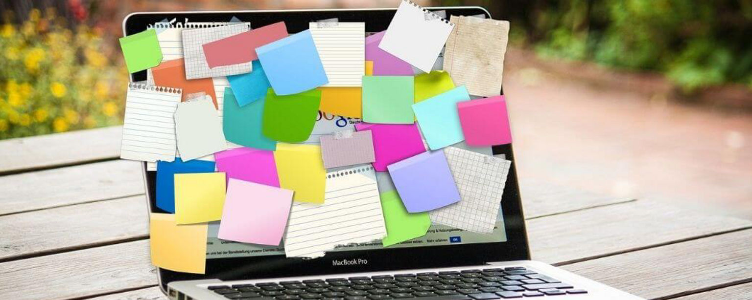 Laptop, dessen Bildschirm mit Post-its in unterschiedlichen Farben und Größen vollgeklebt ist